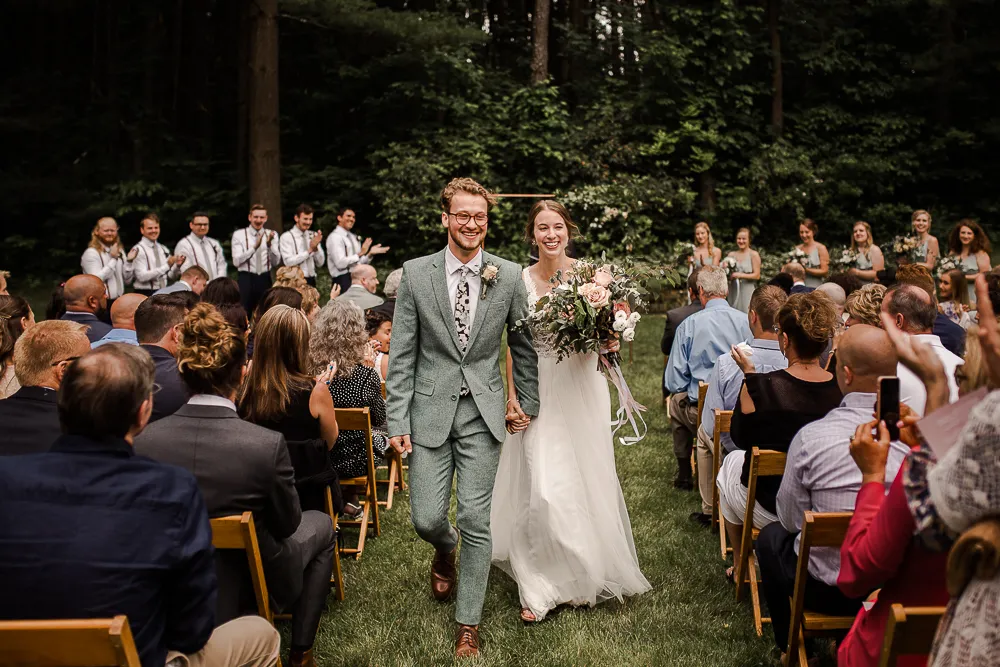 ben and alexis walking down the aisle at our outdoor ceremony area