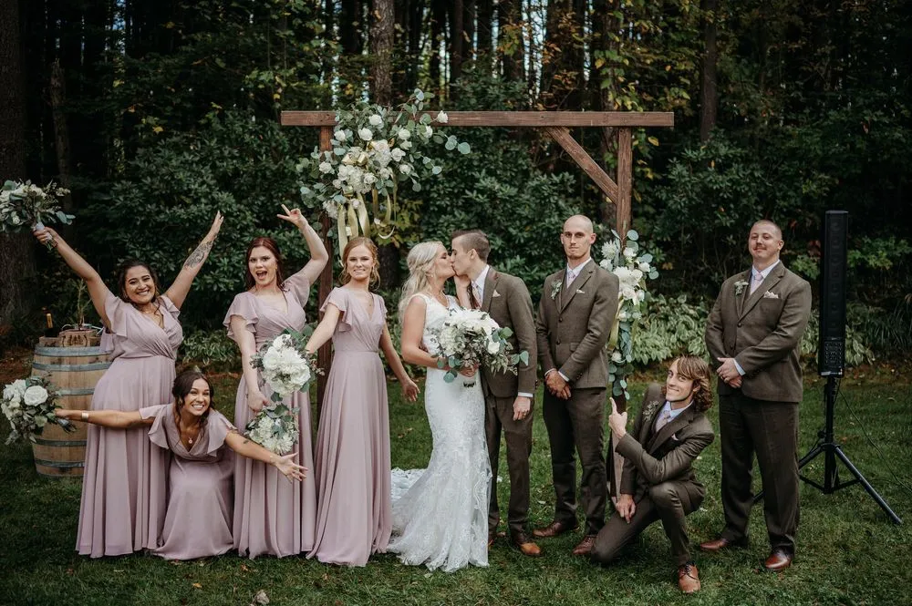 bride and groom kissing with bridal party