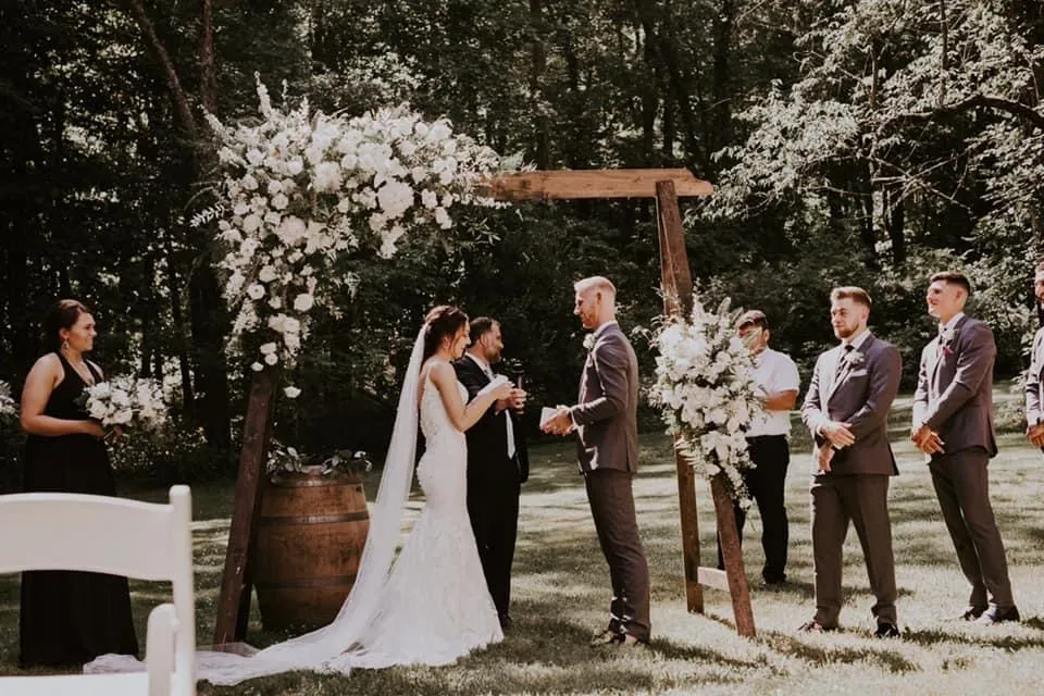 wedding couple under a rectangular arch with florals